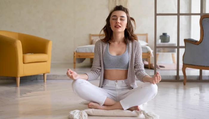 Woman meditating peacefully at home in a bright, serene room