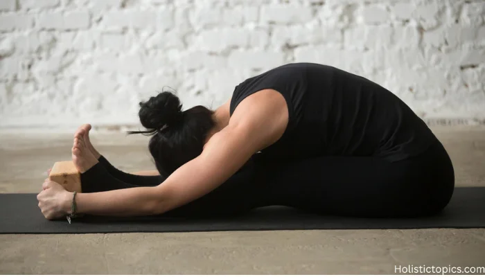 woman practicing seated forward fold pose for beginner yoga for stress relief on a yoga mat.